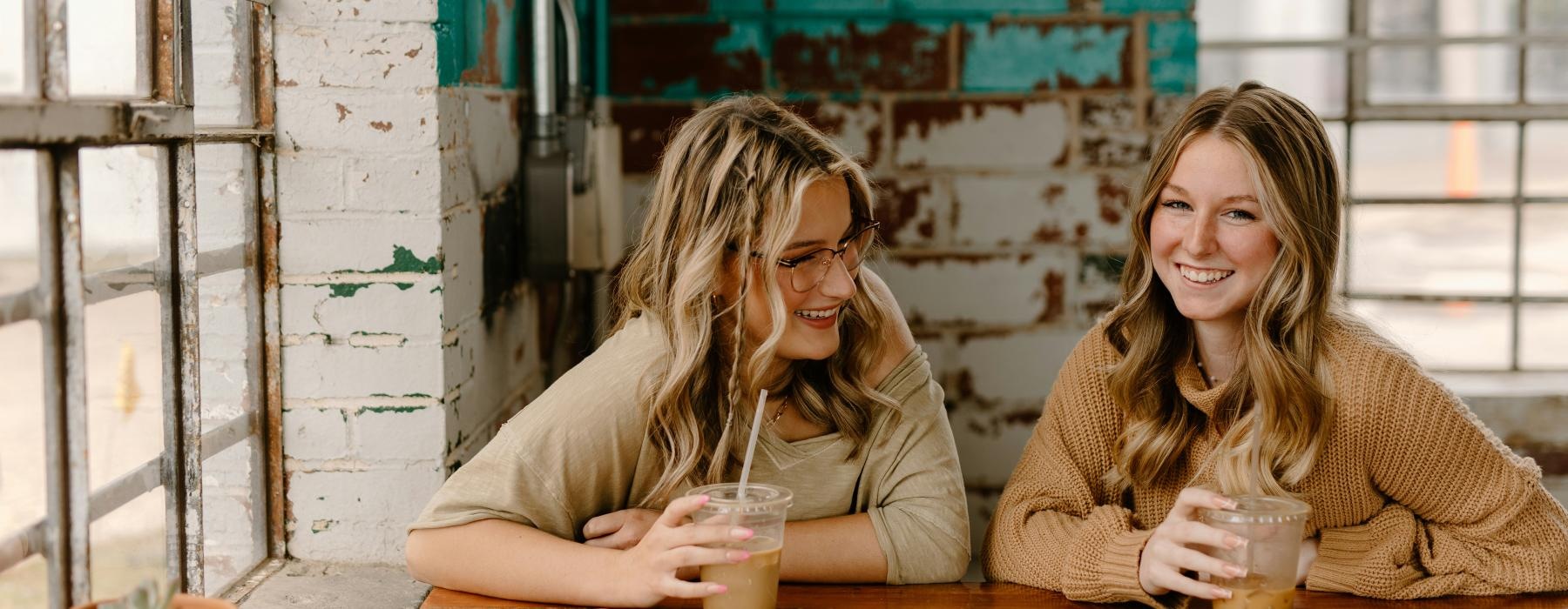 a couple of women sitting at a table with drinks