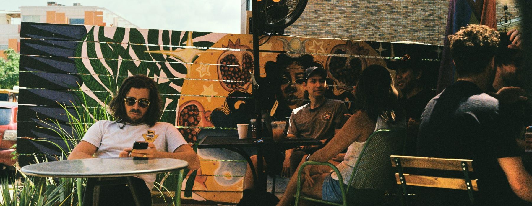people sitting at tables under umbrellas